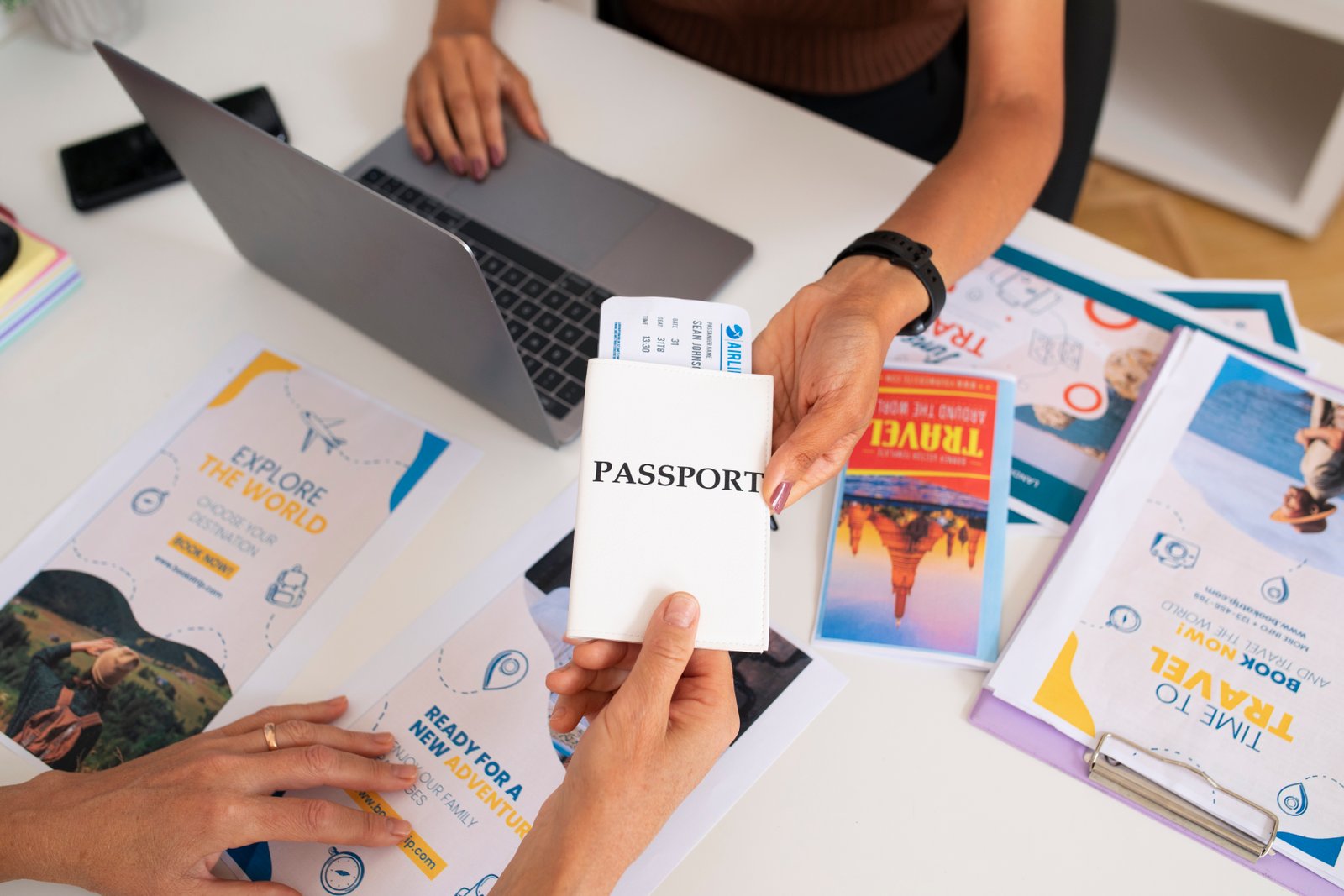 Uploaded imagehigh-angle-travel-agency-desk-with-people-working-laptop-holding-passport.jpg